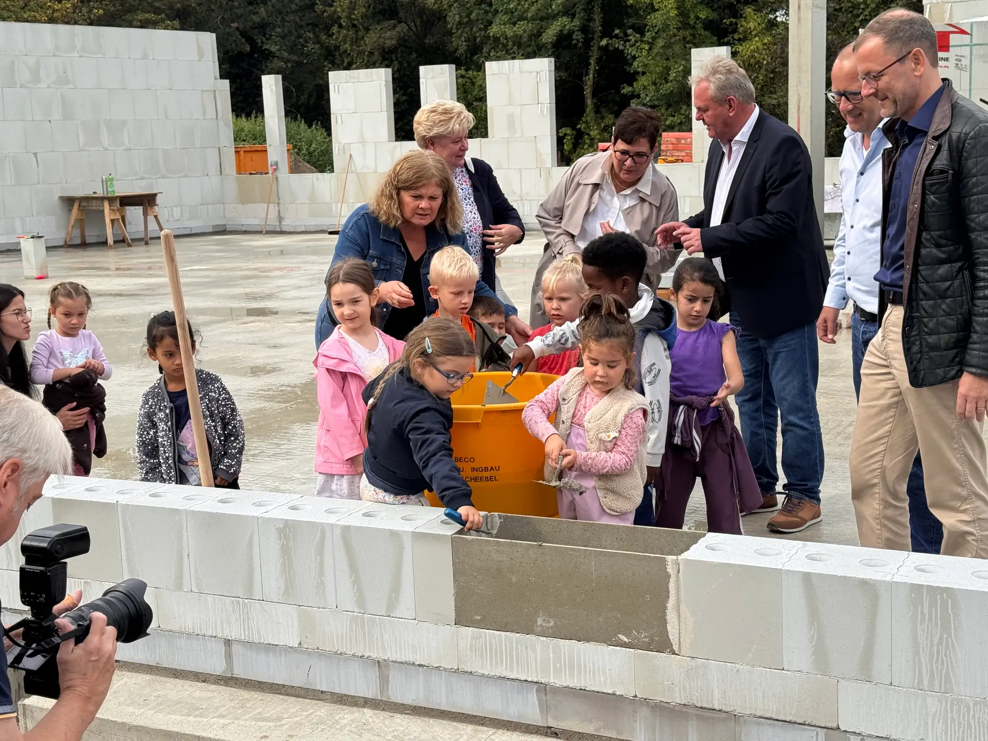 Kita-Kinder legten gemeinsam mit Erzieherinnen, Robert Reichstein vom Amt für Jugend, Familie und Frauen (2. von rechts) und Dezernent Martin Günthner (ganz rechts) den Grundstein für die Kita Weichselstraße.